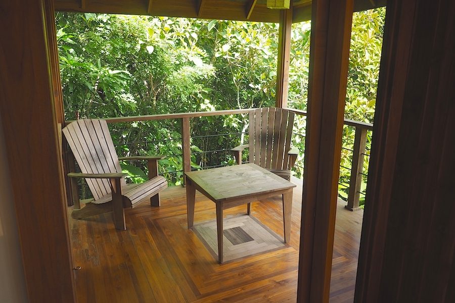 Adirondack chairs on the private covered deck of the Jungle Canopy Bungalow
