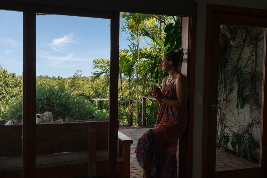 Guest looking out over the rainforest from the Sunrise Studio deck door