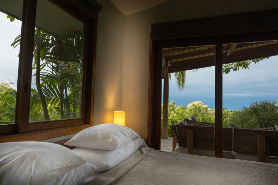 King bed in the Sunrise Studio with sliding doors and treetop views